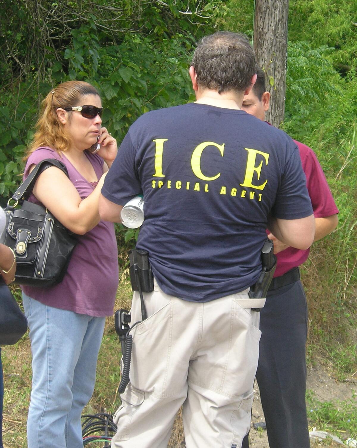Un agente del Servicio de Inmigración y Aduanas (ICE) conversa con varias personas. EFE/Archivo