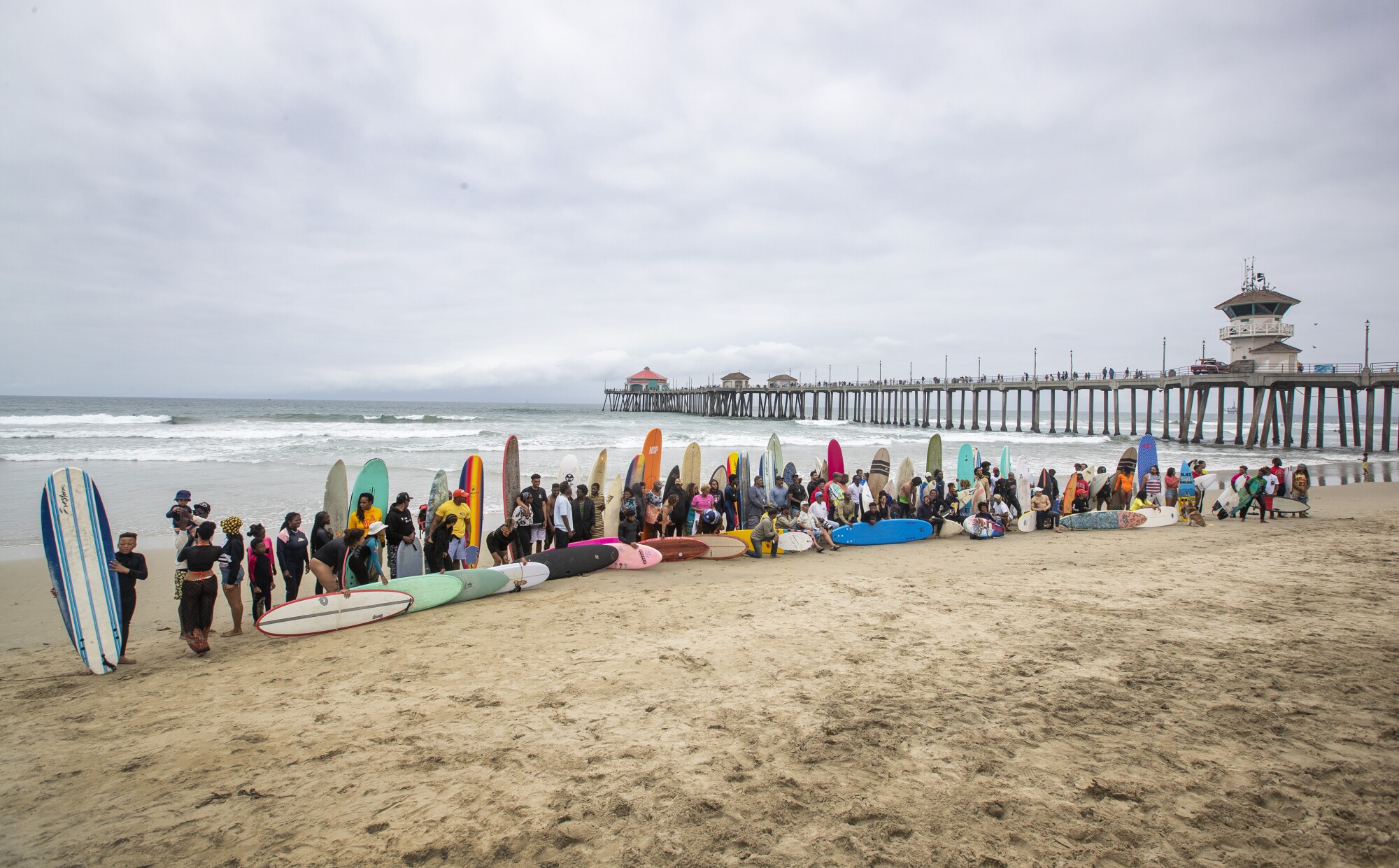 People with surfboards line up for a photo.