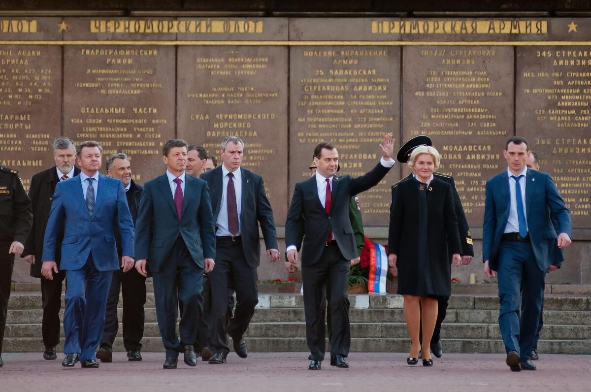 Russian Prime Minister Dmitry Medvedev waves as he leads a delegation of Russian government officials on a visit to Crimea, visiting the World War II Memorial to the Heroic Defense of Sevastopol.