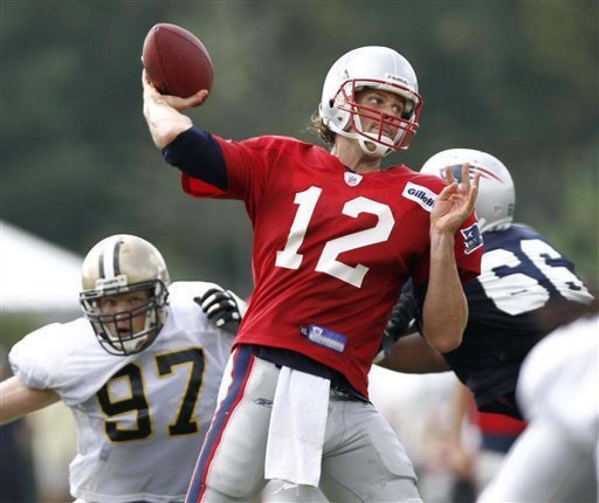 New England Patriots quarterback Tom Brady (12) wipes the sweat