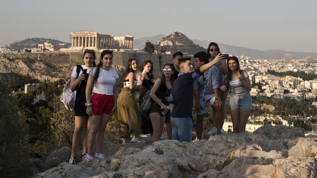 Young tourists pause for photos in Athens.