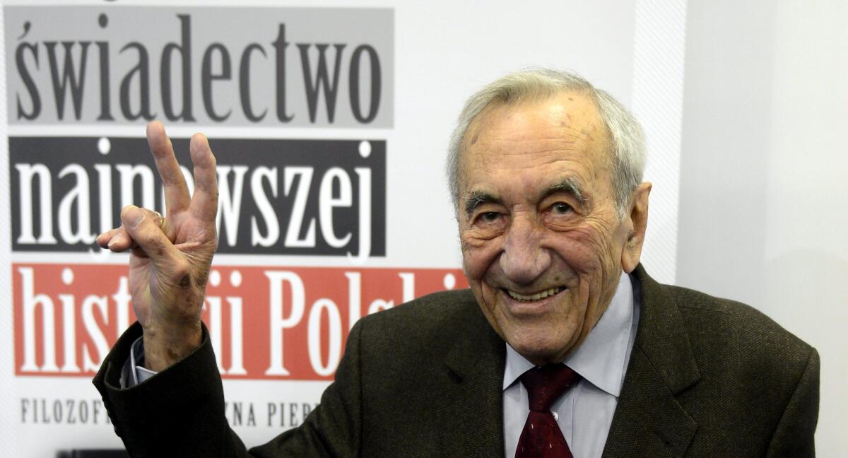 Former Polish Prime Minister Tadeusz Mazowiecki gesturing the 'V' sign during a 2012 press conference in Warsaw for his book ''The Year 1989 and the following years.''
