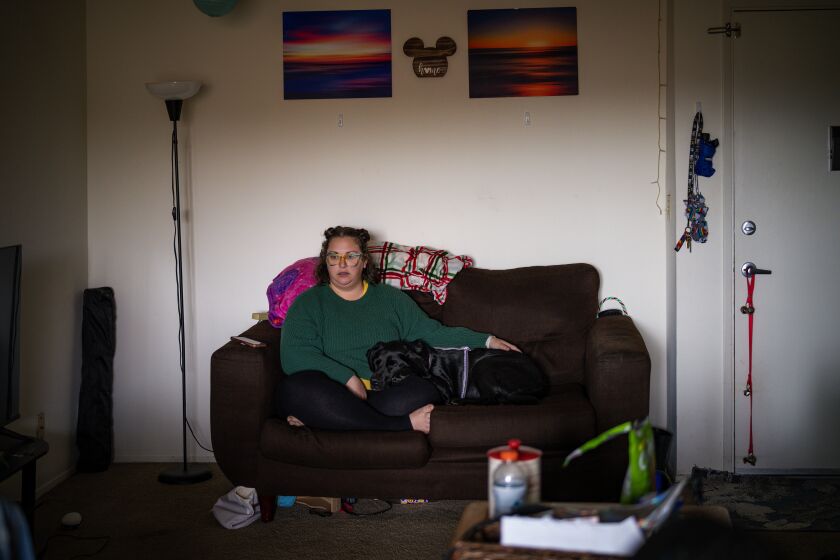 San Diego, CA - March 10: Alyssa Salter at her apartment with her service dog, Leia on Friday, March 10, 2023 in San Diego, CA. Salter is immunocompromised who contracted COVID-19 last summer. Salter has several chronic conditions, in addition to fibromyalgia, asthma, and psoriasis.(Nelvin C. Cepeda / The San Diego Union-Tribune)