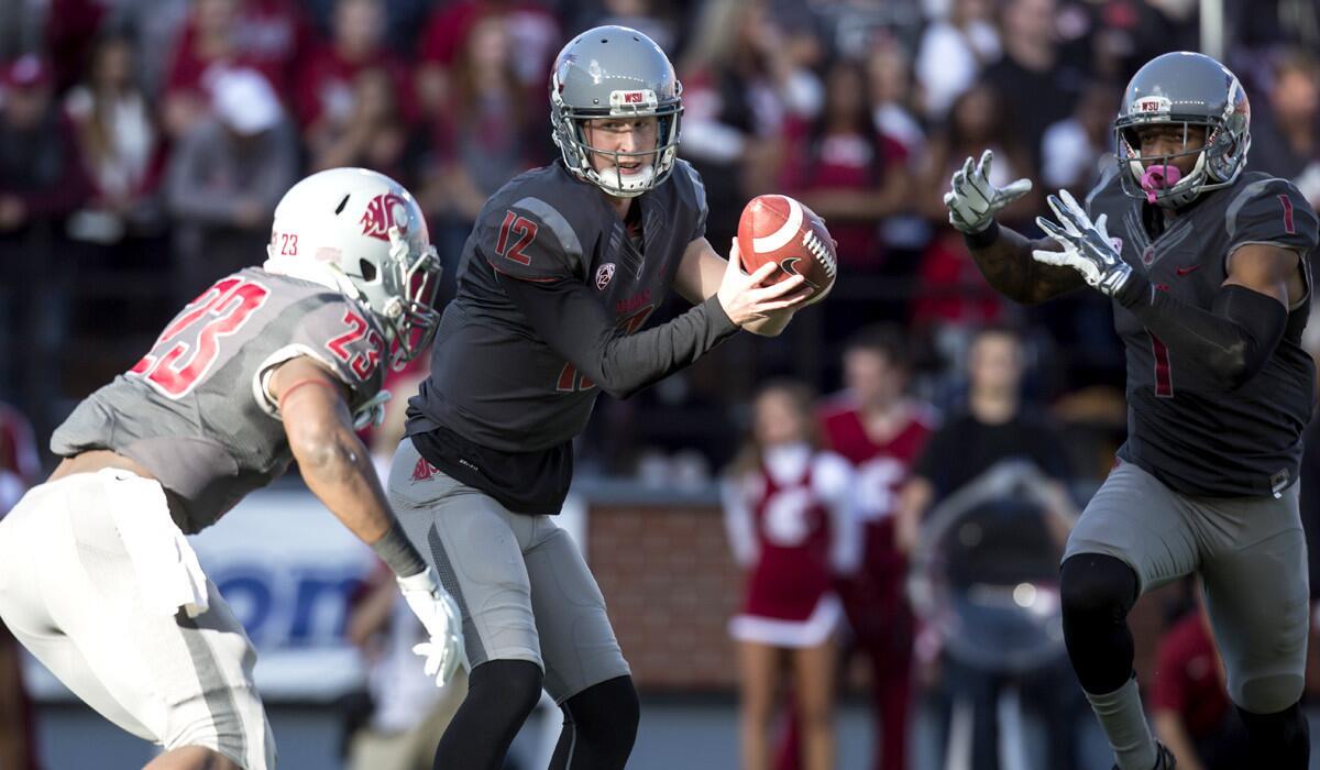 Washington State quarterback Connor Halliday (12) gets set to hand off to running back Gerard Wicks (23) as wide receiver Vince Mayle fakes a reverse during their game against Arizona last week. Handing off is ararity for Halliday.