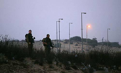 Israeli soldiers guard the border at dawn between Israeli settlements and the Palestinian Gaza Strip to guard against attacks during the pullout.