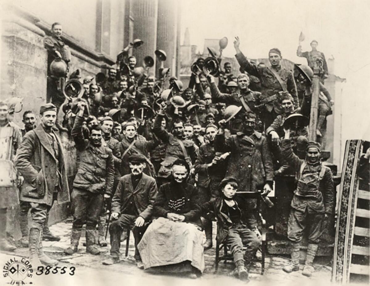 A historic black-and-white image of 353rd Reg. Infantry, 89th Division, at church steps, waving.