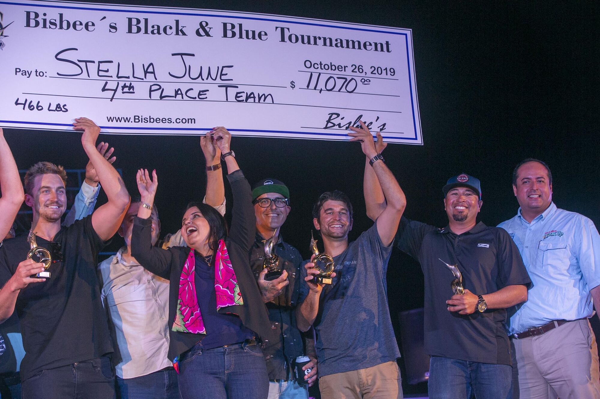 Team members of the Stella June and local dignitaries celebrate as they held up a giant check for $11,070, for a fourth place finish in the Bisbee Black & Blue marlin fishing tournament.