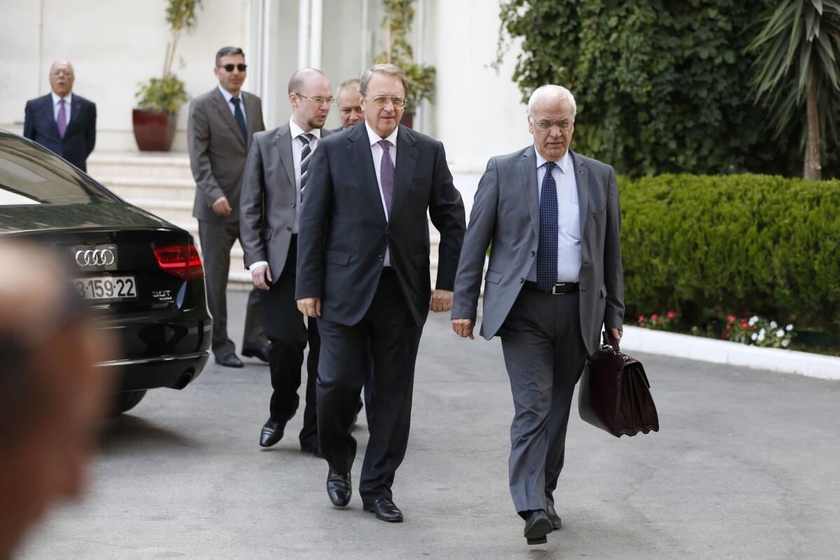 Russian Middle East envoy Mikhail Bogdanov, left, and Palestine Liberation Organization Secretary-General Saeb Erekat walk together after meeting in the West Bank city of Ramallah on Sept. 6.