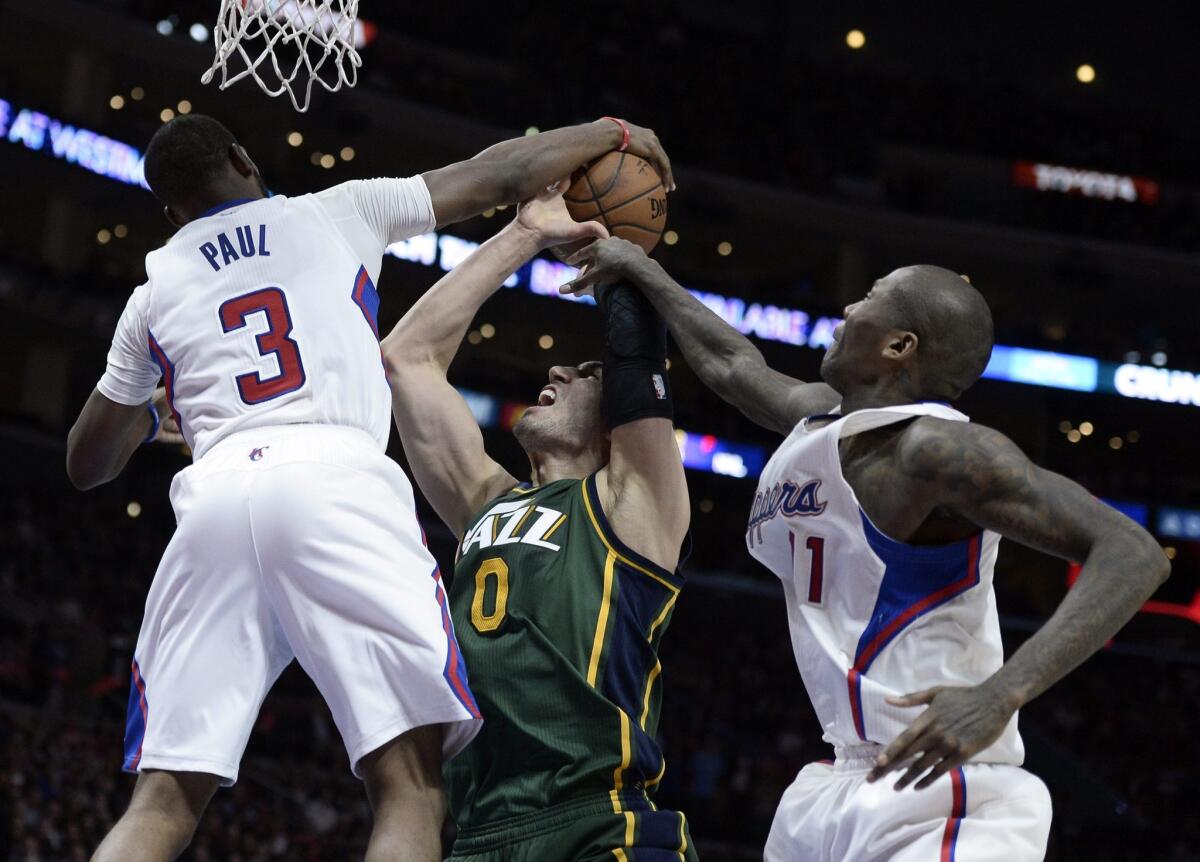 The Clippers' Chris Paul (3) and Jamal Crawford defend Utah's Enes Kanter (0) on Monday night.