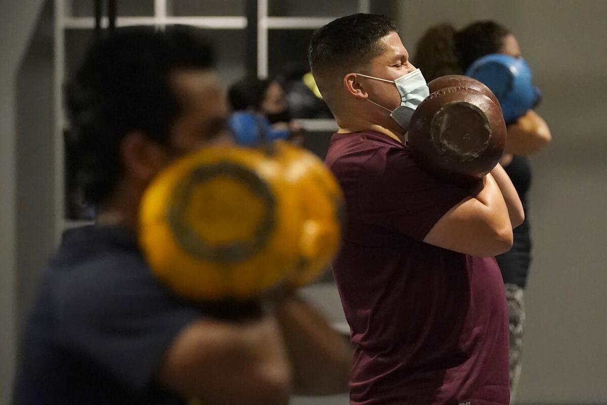 Juan Avellan and others wear masks while working out