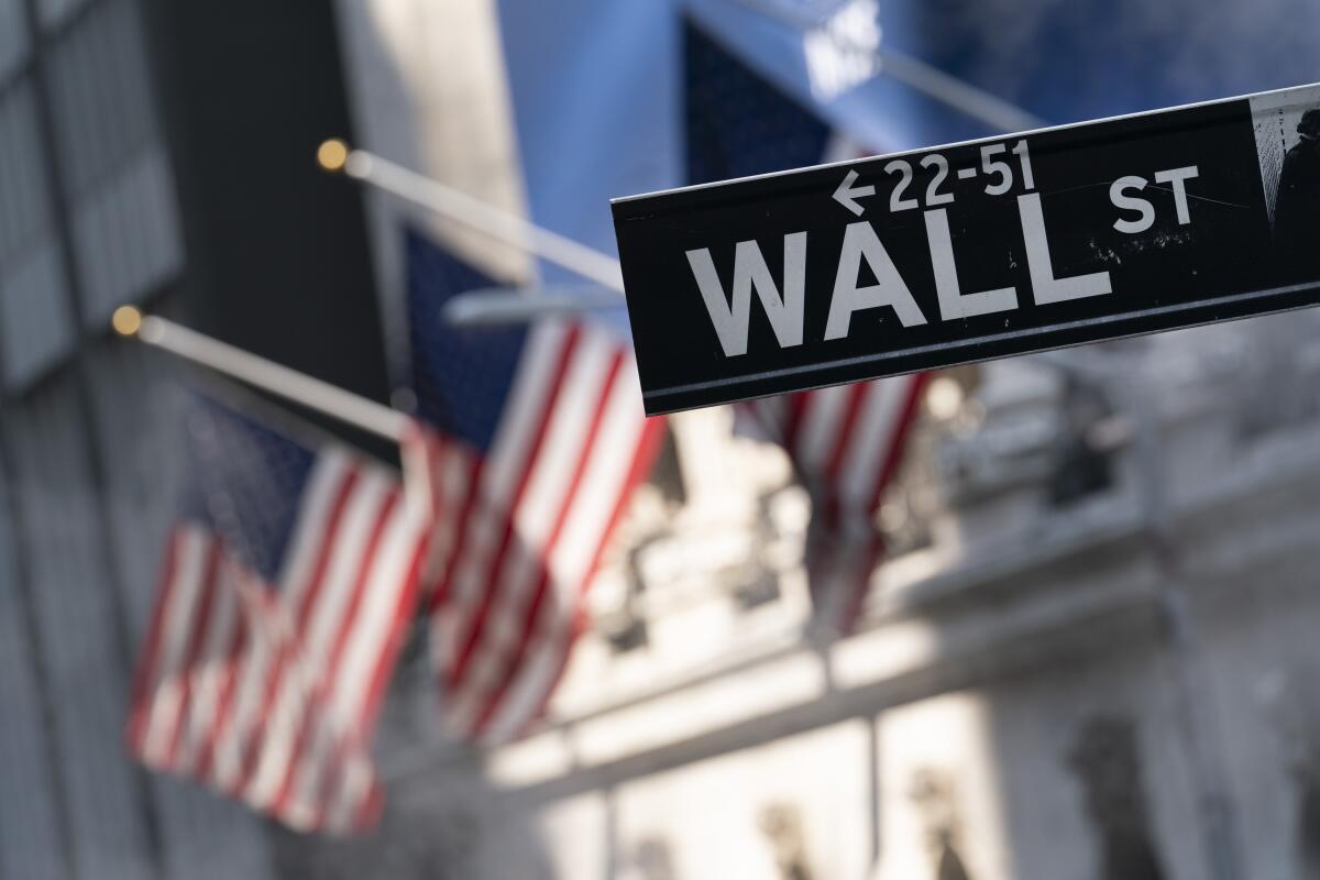 A Wall Street sign hangs in front of the New York Stock Exchange.