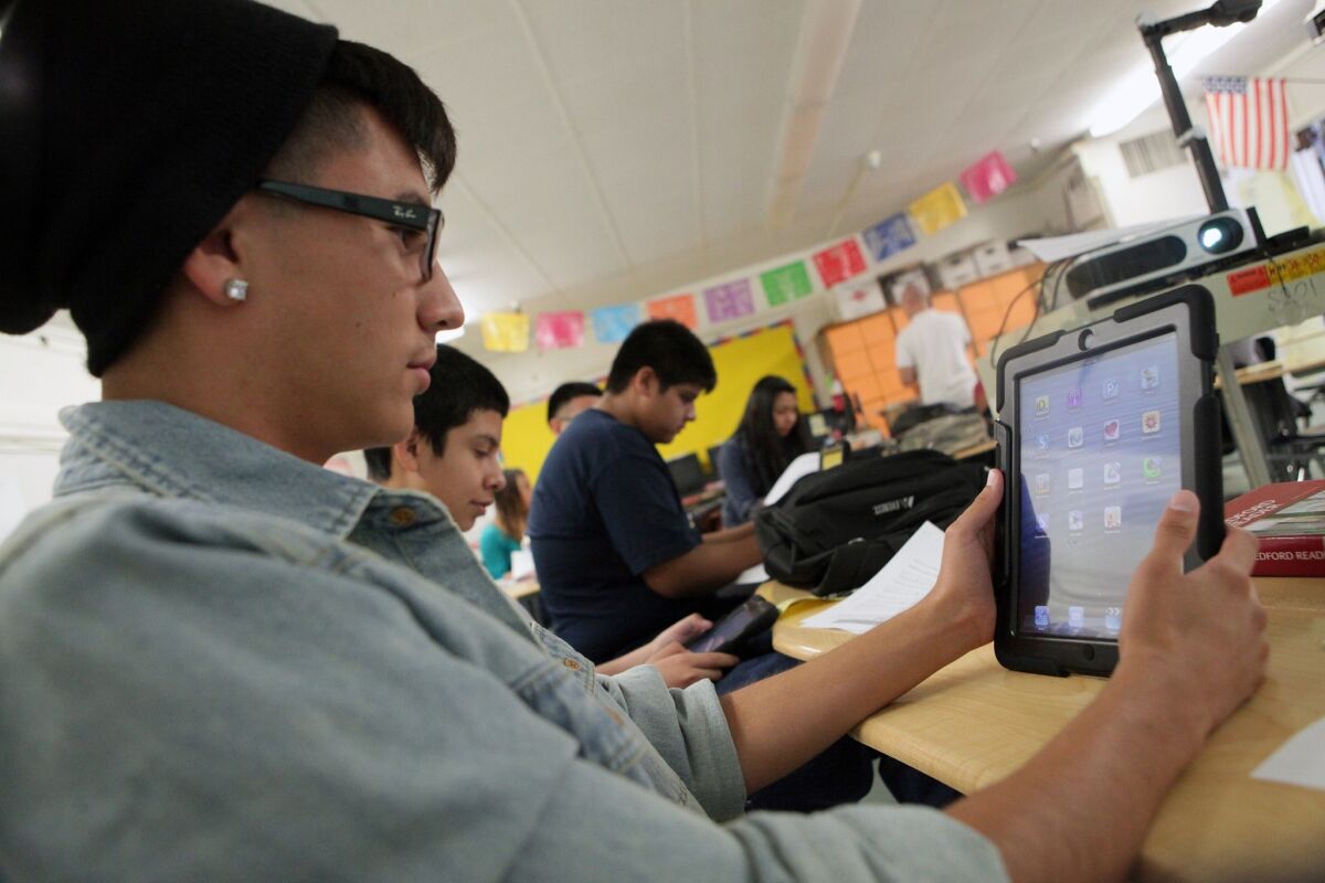 Students at Theodore Roosevelt High School explore iPads provided by L.A. Unified, part of the district's $1.3-billion technology program.