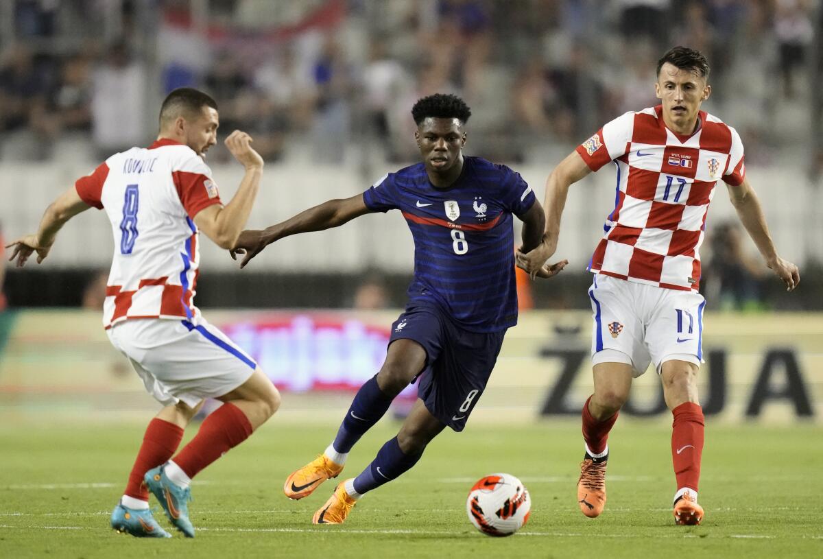 France's Aurelien Tchouameni, center, duels for the ball with Croatia's Mateo Kovacic, left, and Croatia's Ante Budimir during the UEFA Nations League soccer match between Croatia and France at the Poljud stadium, in Split, Croatia, Monday, June 6, 2022. (AP Photo/Darko Bandic)