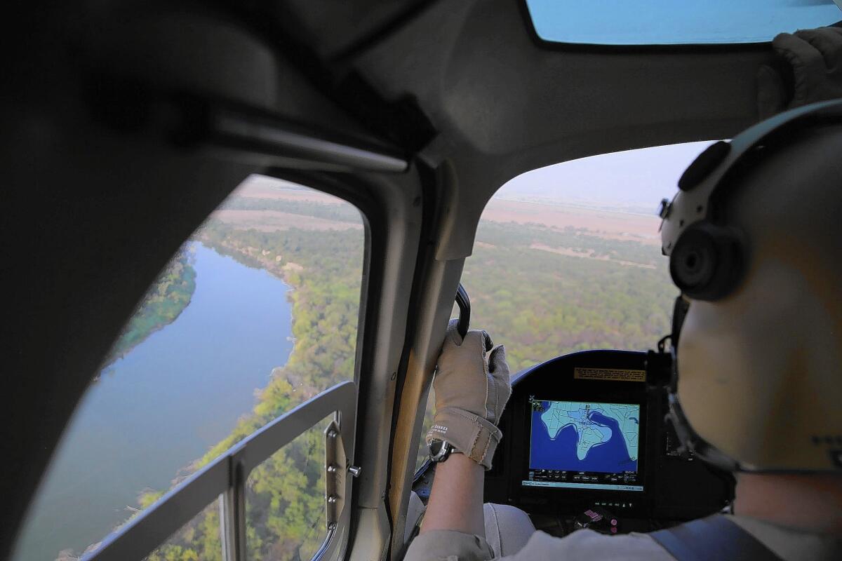 A U.S. aircraft patrols over the Rio Grande near Mission, Texas, a region where tens of thousands of unaccompanied minors have surged across the border, overtaxing a variety of government resources.