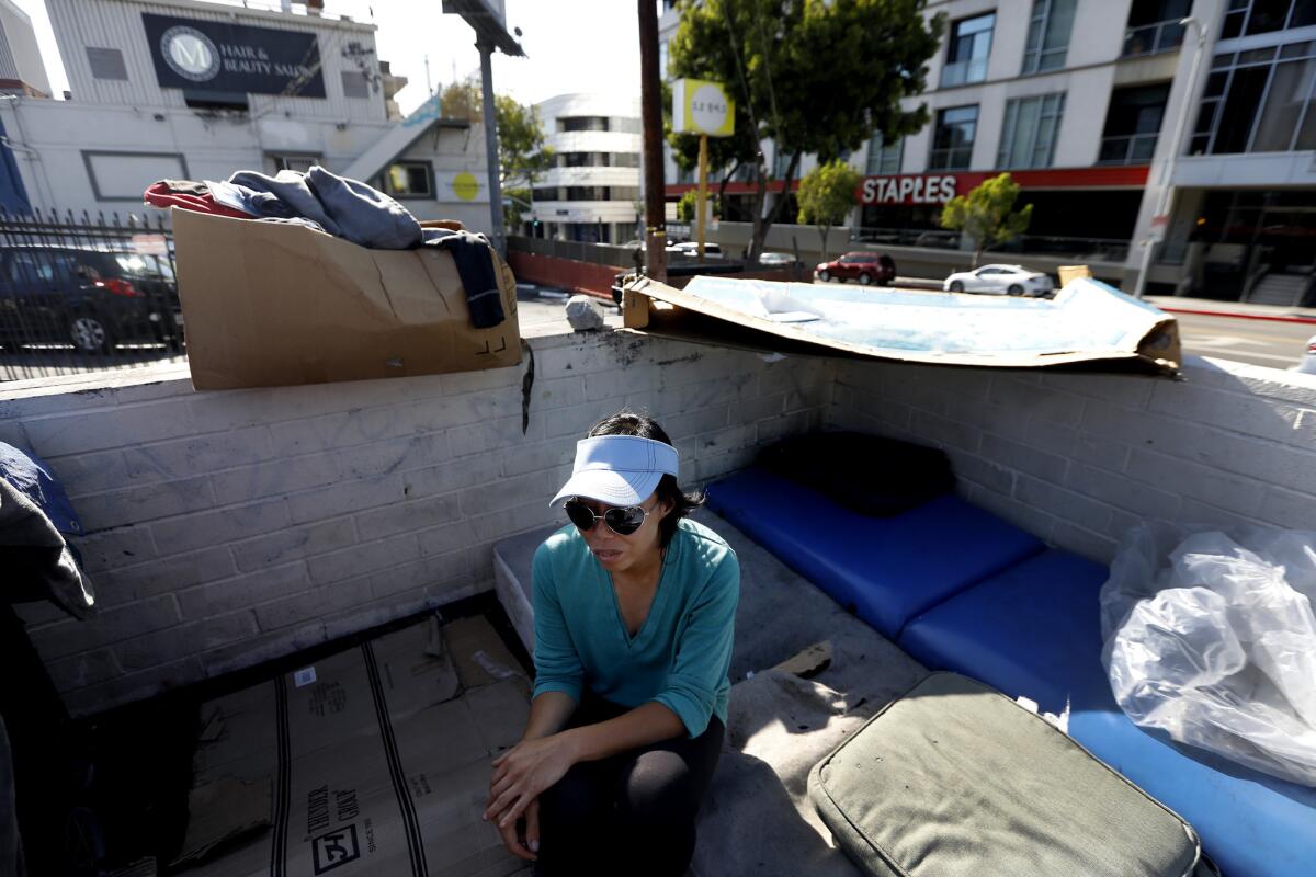 Denise Lee, 35, sits next to her tent in a parking lot near 6th and Vermont in Koreatown. She is one of more than 400 people living on the streets in Koreatown, where a proposed temporary shelter has been met with opposition.