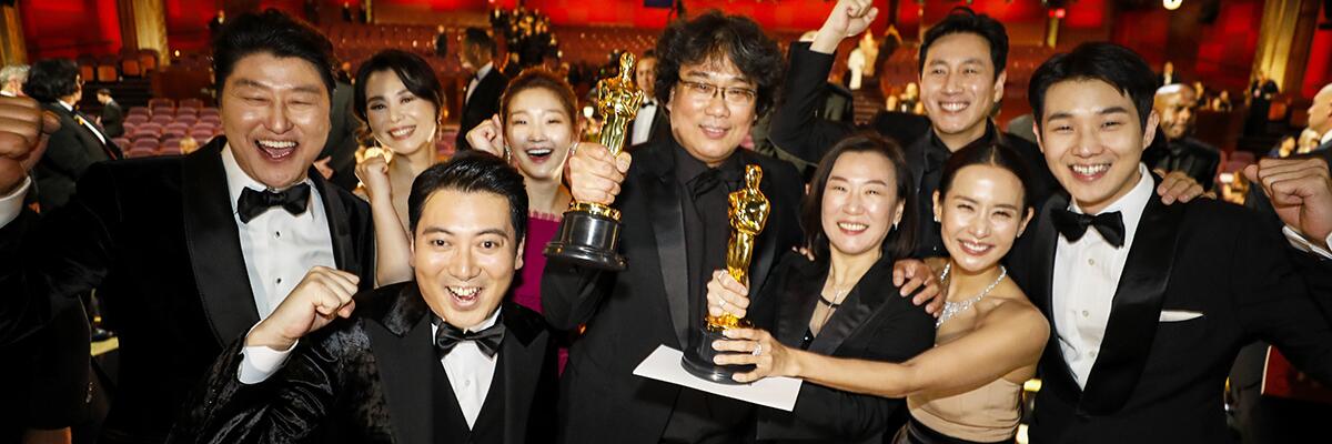 The cast of “Parasite” — and Filmmaker Bong Joon Ho, center — celebrate.
