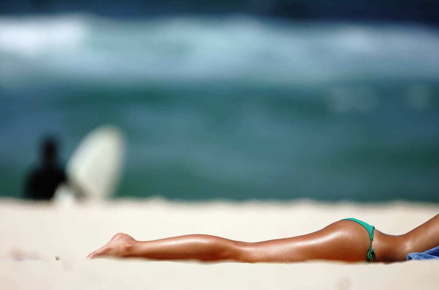 A sunbather soaks up the summer sun on Bondi Beach.