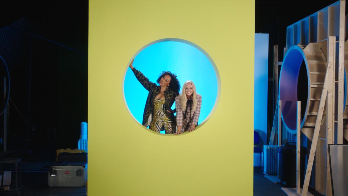 Two women posing in a circle in a green wall on a sound stage