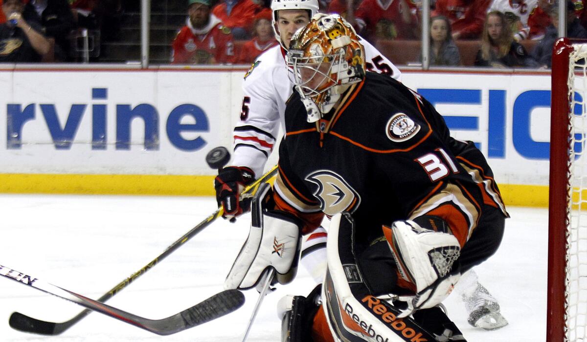 Ducks goalie Frederik Andersen looks to block a shot in the first period as Blackhawks center Andrew Shaw (65) skates into position for a rebound.