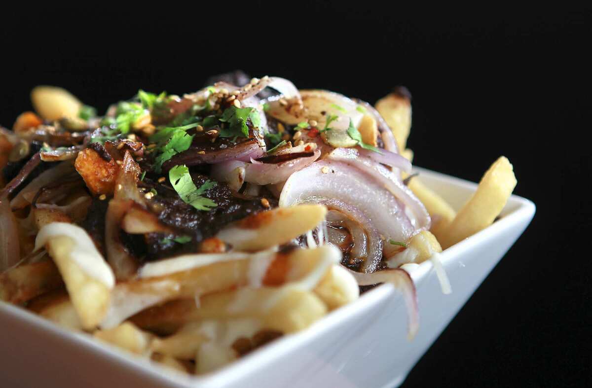 A dish of mole fries with mole poblano gravy, melted cheese, grilled onions and fries at Ricardo Diaz's new restaurant Bizarra Capital.