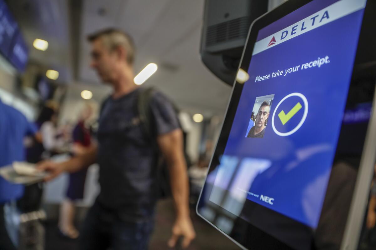 A screen at the airport shows approval of face ID for a passenger