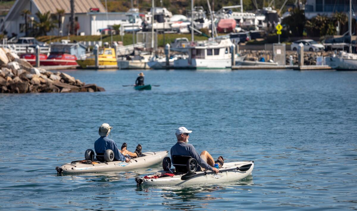 Kayakers make the way around Oceanside Harbor on Wednesday. 