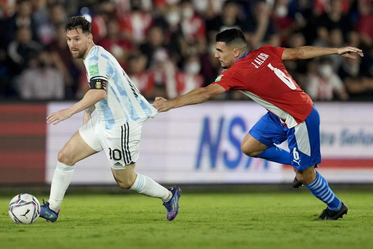 El delantero argentino Lionel Messi avanza con el balón frente al paraguayo Junior Alonso.