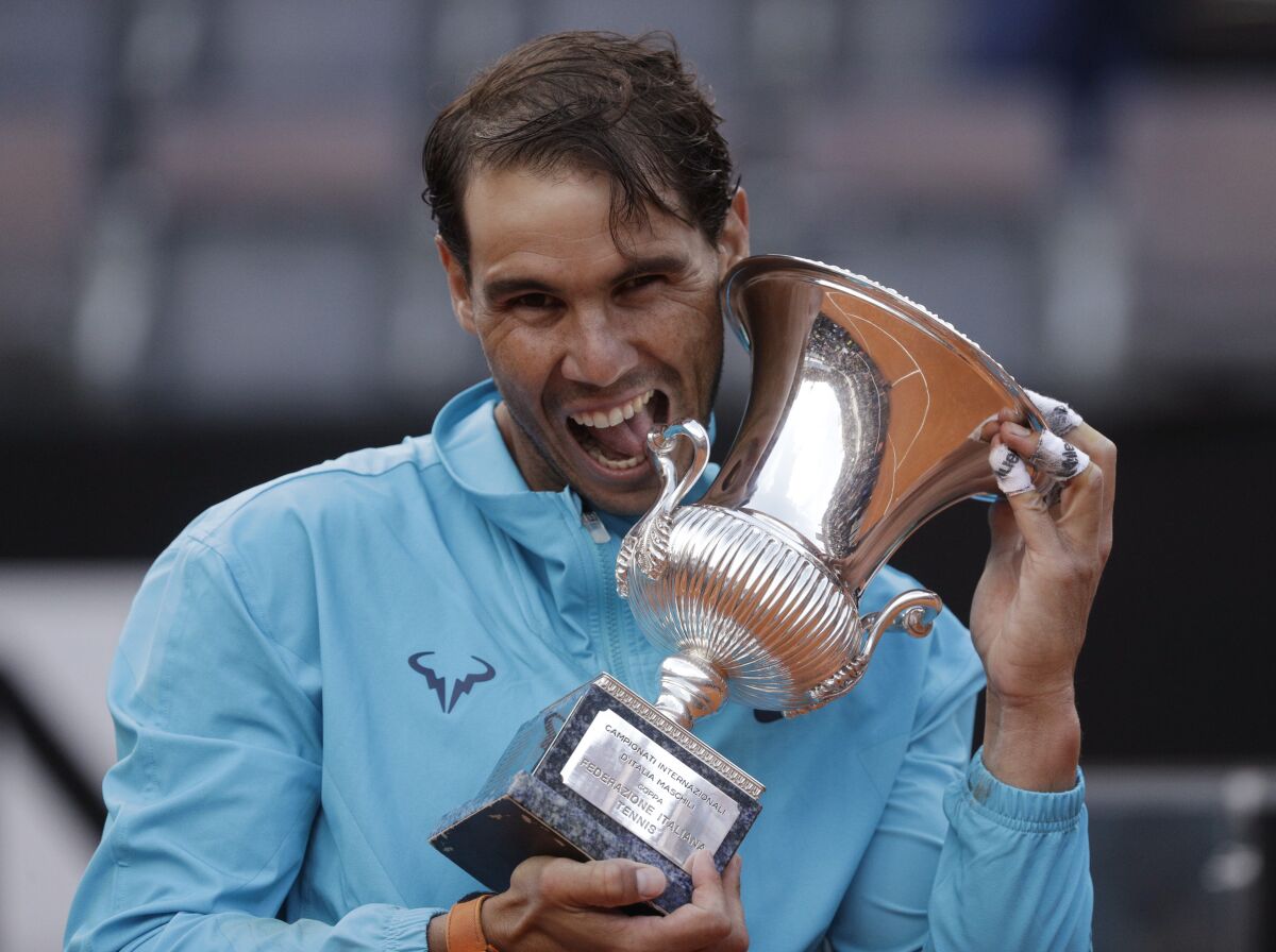 FILE - In this May 19, 2019 file photo, Rafael Nadal of Spain holds his trophy after winning against Novak Djokovic of Serbia at the end of their final match at the Italian Open tennis tournament, in Rome. Rafael Nadal is preparing his return to tennis after a seven-month layoff at next week’s Italian Open. “The Foro Italico is always a special place for me and even more so this year as it will be my first tournament following a long period without playing,” Nadal, who has won the Rome tournament a record nine times, said in a video message played at the event’s presentation Tuesday, Sept. 8, 2020. (AP Photo/Gregorio Borgia)
