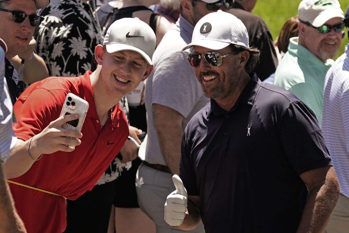 Phil Mickelson poses for a photo with a fan during a practice round ahead of the U.S. Open golf tournament, Tuesday, June 14, 2022, at The Country Club in Brookline, Mass. (AP Photo/Charlie Riedel)