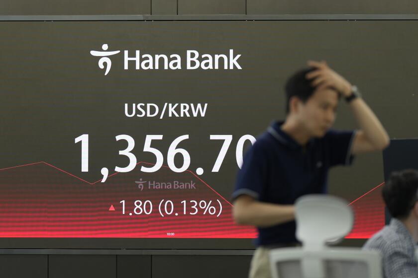 A currency trader walks by the screen showing the foreign exchange rate between U.S. dollar and South Korean won at a foreign exchange dealing room in Seoul, South Korea, Monday, May 20, 2024. Asian stocks advanced Monday after U.S. stock indexes drifted near their records and the Dow Jones Industrial Average finished above the 40,000 level for the first time.(AP Photo/Lee Jin-man)