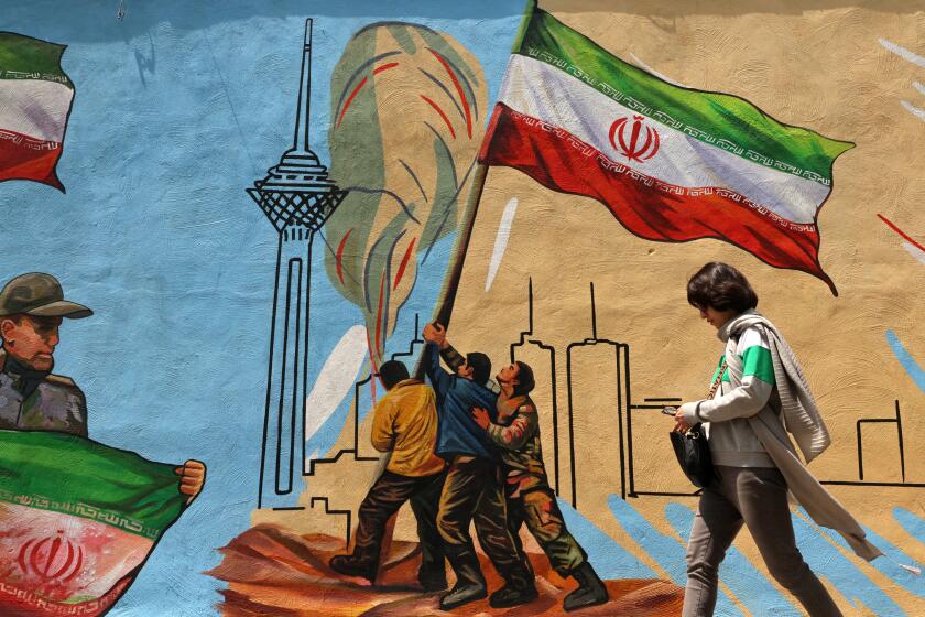 An Iranian woman walks past an anti-USA and anti-Israel mural, in Tehran on April 21 2026, amid a ceasefire in the region. With the end of a two-week ceasefire approaching, the White House said US Vice President was ready to return to Pakistan for fresh negotiations to end a conflict that has sent crude soaring and revived inflation fears. (Photo by ATTA KENARE / AFP via Getty Images) /