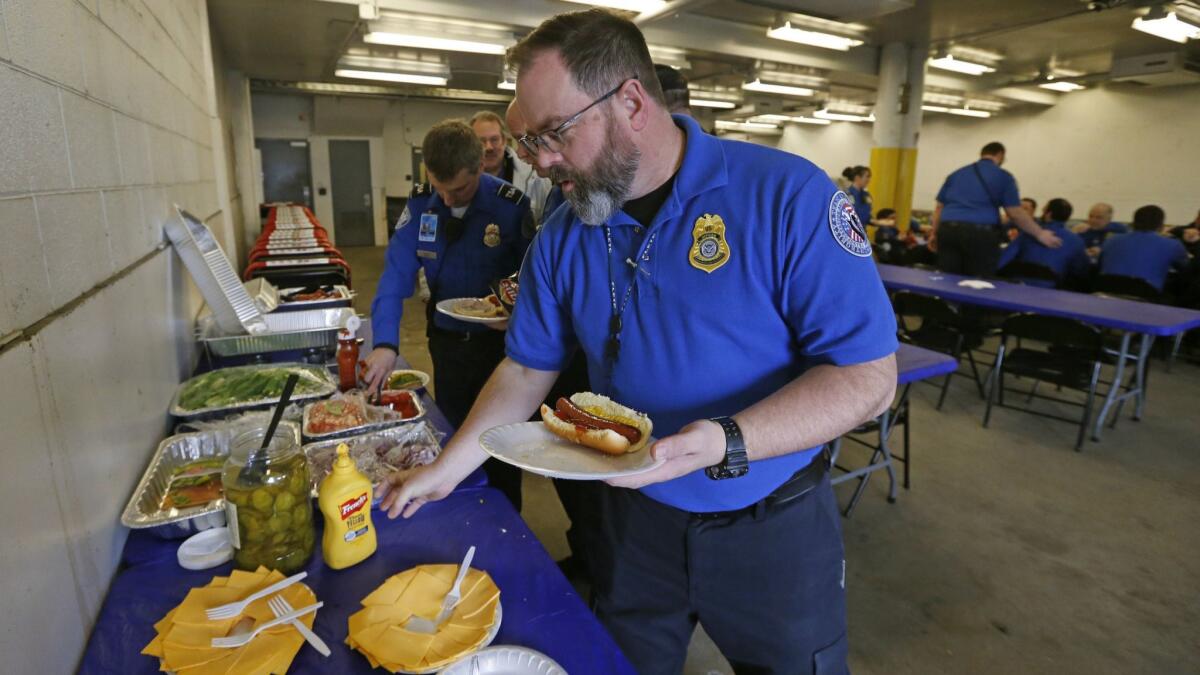 Transportation Security Administration employee Gary Vetterli eats lunch at Salt Lake City International Airport on Wednesday. Officials at the Utah airport treated workers from the TSA, Federal Aviation Administration and Customs and Border Protection to a free barbecue lunch.