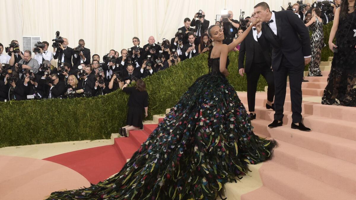 Designer Stefano Gabbana greets Zoe Saldana, in a feathered Dolce & Gabbana gown with a dramatic train, at the Metropolitan Museum of Art's Costume Institute benefit gala on May 2, 2016, in New York.