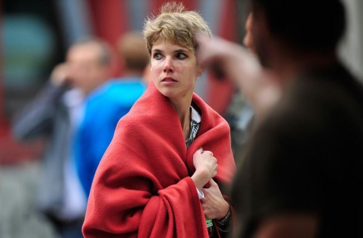 A woman wrapped in a blanket leaves the scene of a hostage-taking at City Hall in Ingolstad, Germany.