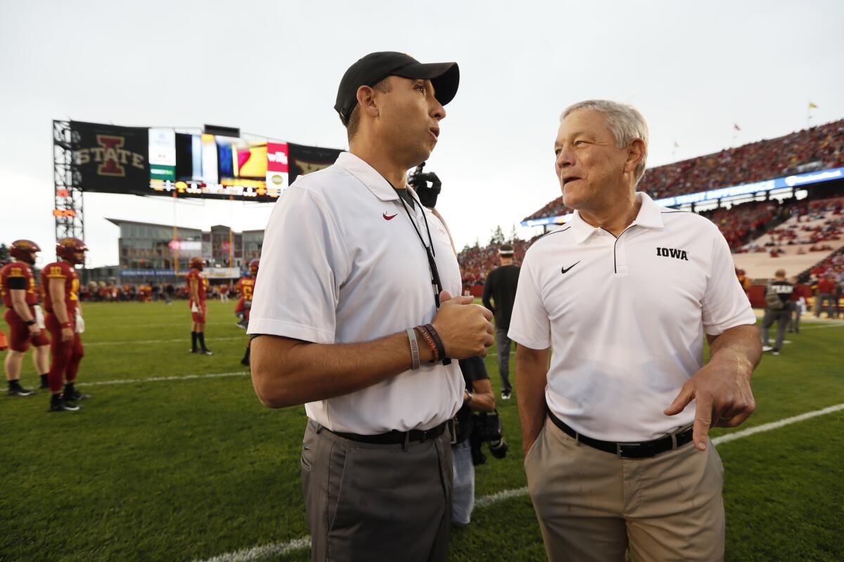 FILE - In this Sept. 14, 2019, file photo, Iowa State head coach Matt Campbell, left, talks with Iowa head coach Kirk Ferentz before an NCAA college football game in Ames, Iowa. Ferentz has been where Campbell is now in his career. Successful coach, courted annually by other schools and the NFL. Ferentz stayed at Iowa and settled into a two-decade run. Heading into the biggest Iowa-Iowa State game in the history of the rivalry, it's hard to know how much longer Campbell will be in Ames. (AP Photo/Charlie Neibergall, File)