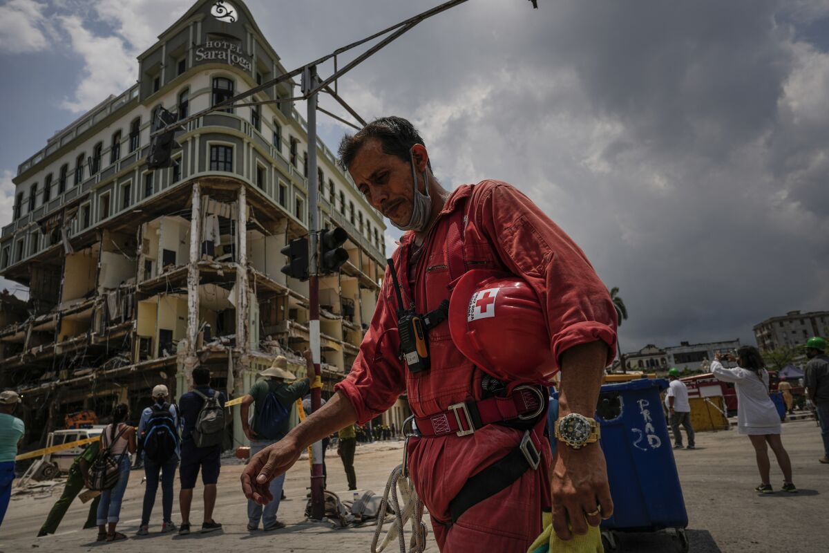 A member of the Cuban Red Cross takes a break after working in the rubble at the site of a deadly explosion that destroyed the five-star Hotel Saratoga in Old Havana, Cuba, Monday, May 9, 2022. (AP Photo/ Ramon Espinosa)