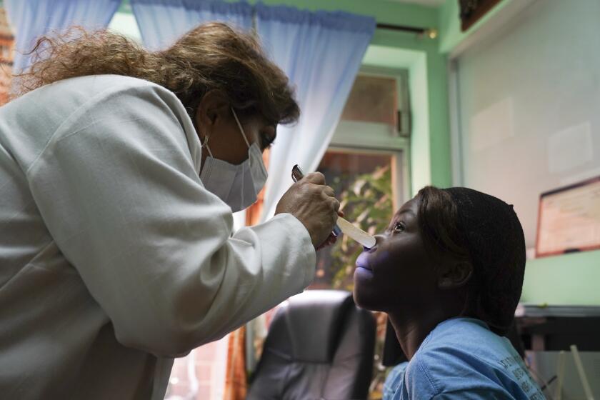 La doctora Sarahí Hernández Pacheco le proporciona atención médica a la haitiana Bellantta Lubin en la clínica Bassuary el jueves 20 de junio de 2024, en Ciudad Nezahualcóyotl, al este de Ciudad de México. (AP Foto/Mariana Martínez Barba)