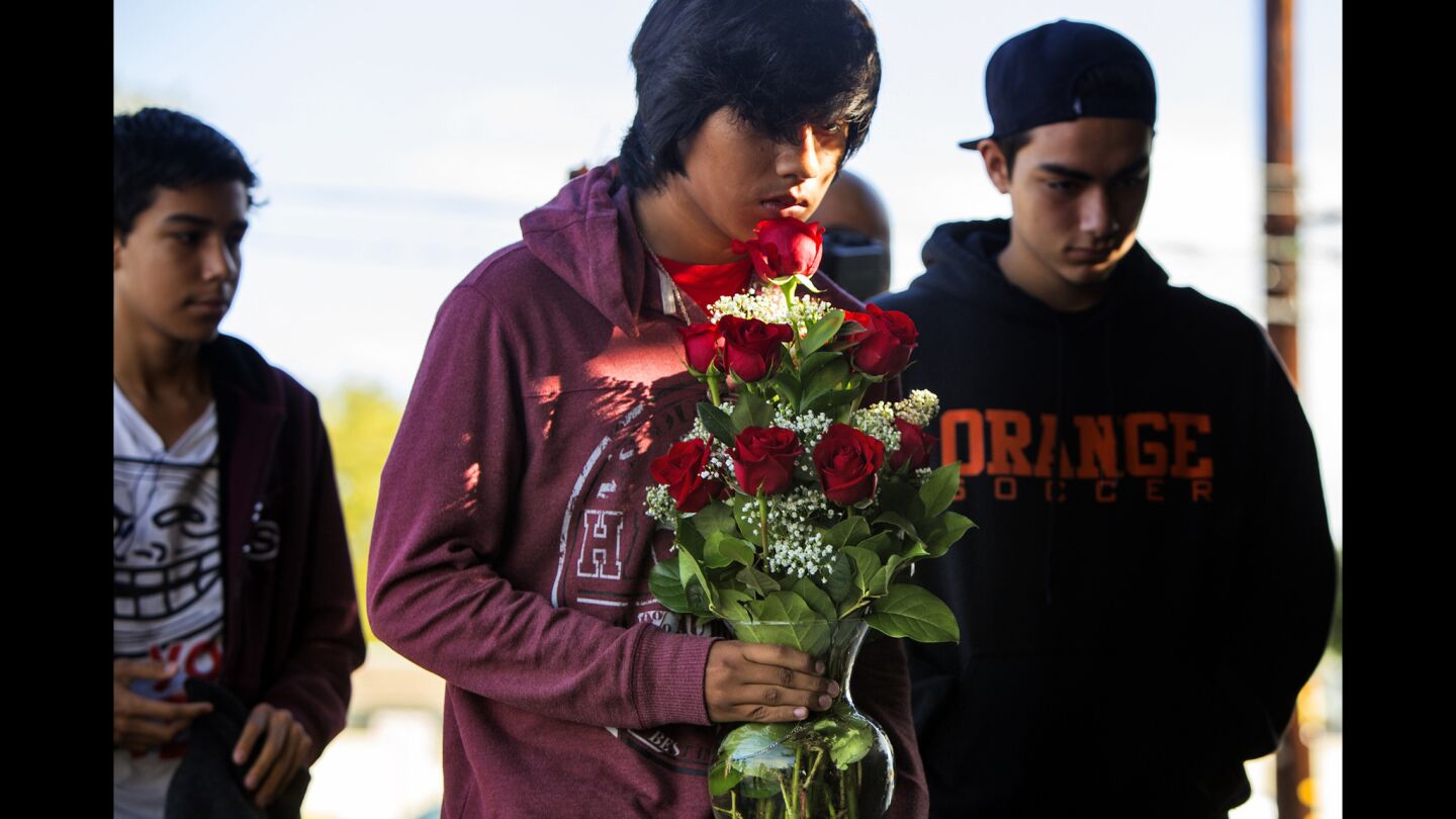 Santi Morales, boyfriend of Andrea Gonzalez, who was killed by a hit-and-run driver, brings flowers to a memorial for Gonzalez and two twin 13-year-old girls.