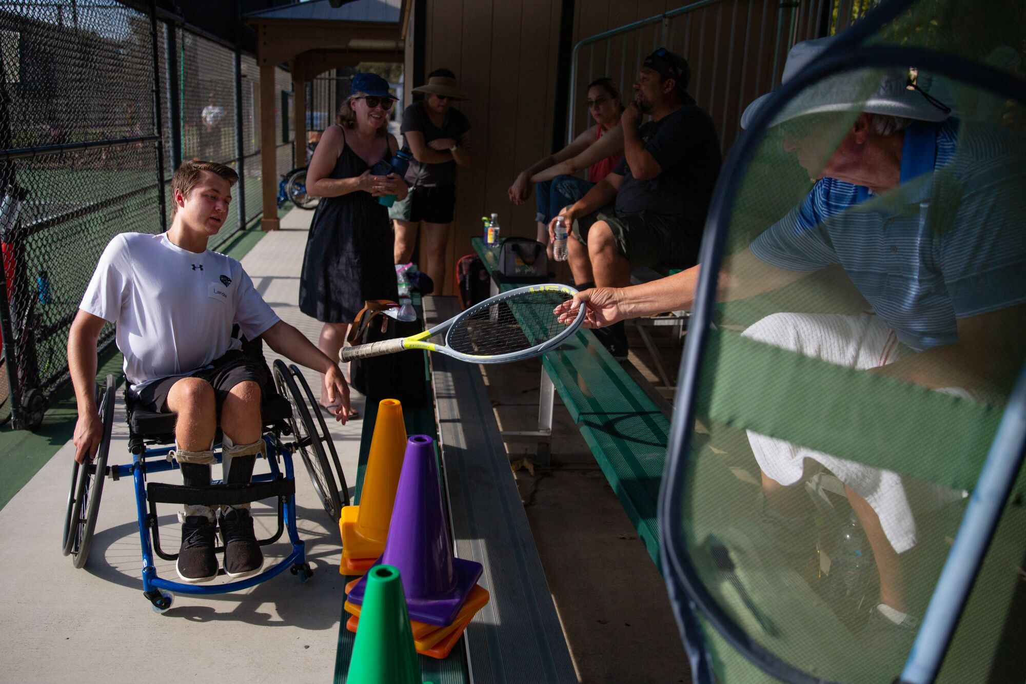 Adaptive tennis player Landon Sachs grabs a racket as he prepares for practice at JSerra High School.