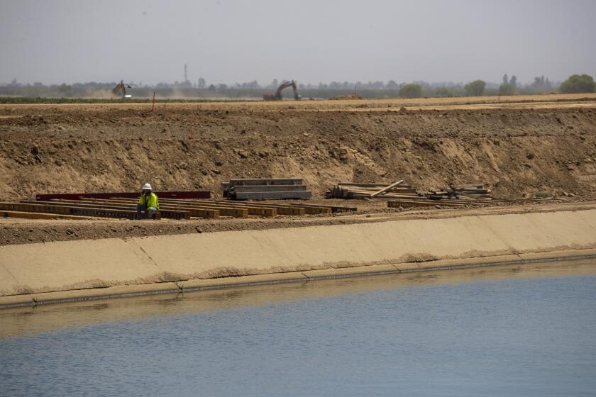 TERRA BELLA, CA - August 16 Construction continues on a section of the Friant-Kern Canal damaged from subsidence, a sinking of the earth from groundwater removal, along the canal's middle reach section on Tuesday, Aug. 16, 2022 in TERRA BELLA, CA. The canal, which provides water to one million acres of farmland and cities, flows 152 miles from Fresno to Bakersfield. (Brian van der Brug / Los Angeles Times)