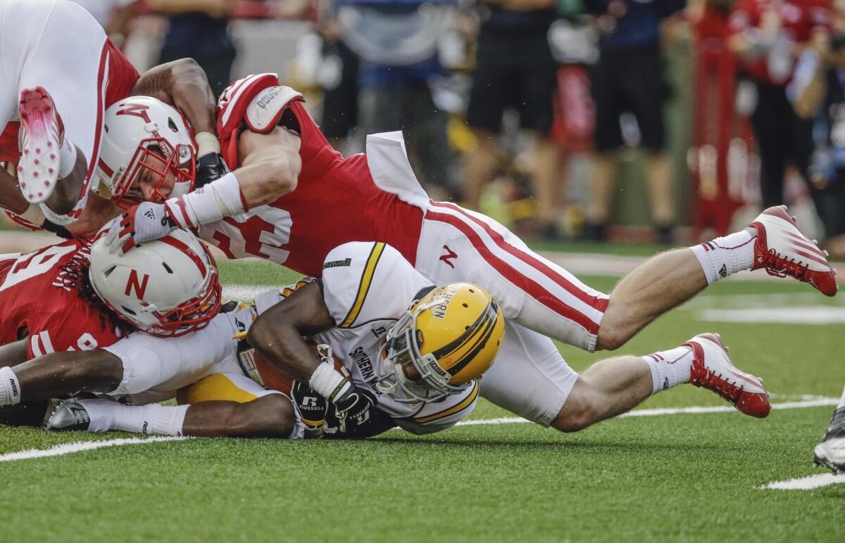 Nebraska freshman linebacker Nathan Gerry, top, and teammate Jason Ankrah tackle Southern Mississippi wide receiver Tyre'oune Holmes during the Cornhuskers' win Saturday.