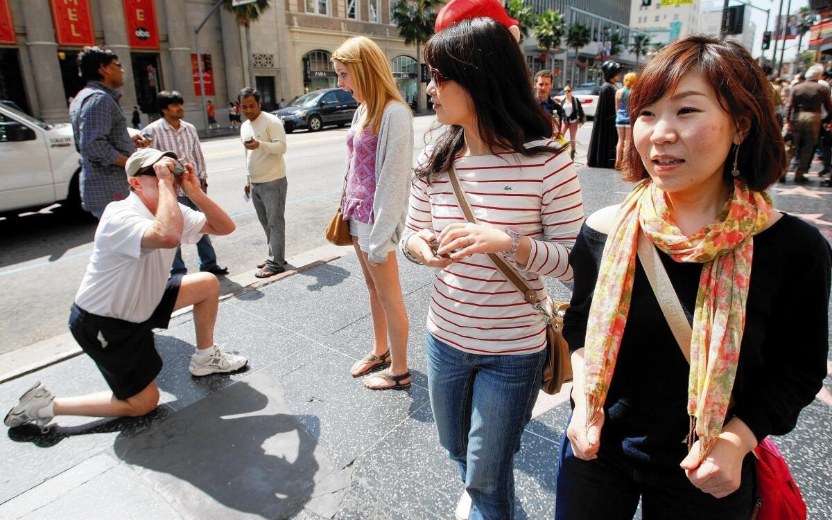 Visitors to L.A. County booked 26.6 million room nights in 2012, spent about $16.5 billion and supported 324,000 jobs in the region, according to a local tourism organization. Above, tourists Yuka Watanabe, right, and friend Miwako Tsugawa in Hollywood in 2011.