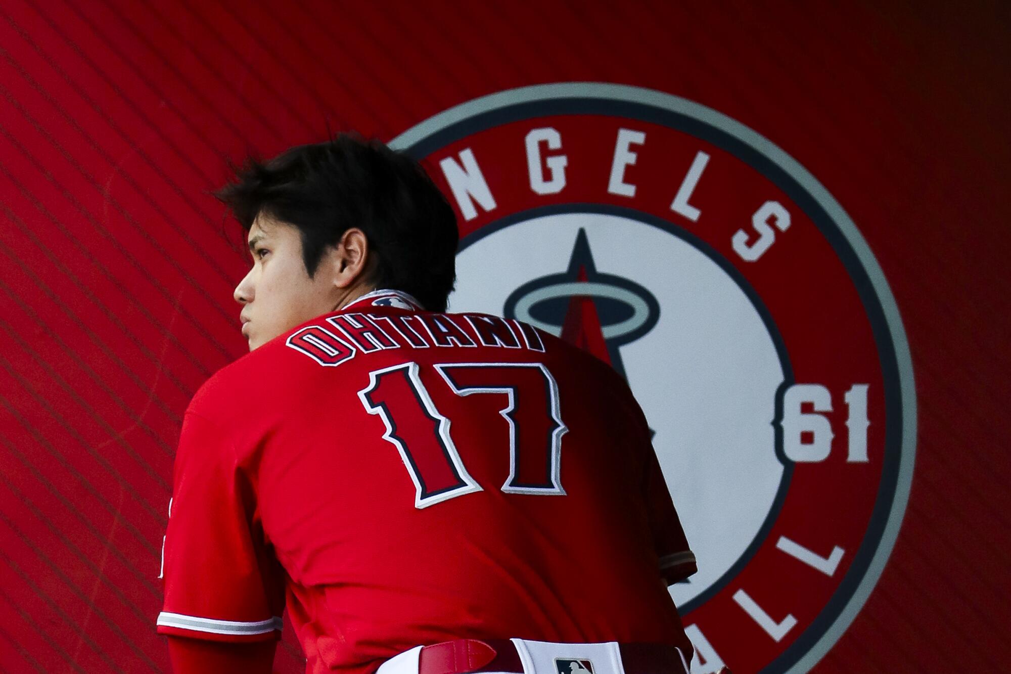 Shohei Ohtani stands in the Angels' dugout during a game against the Yankees in July 2023.