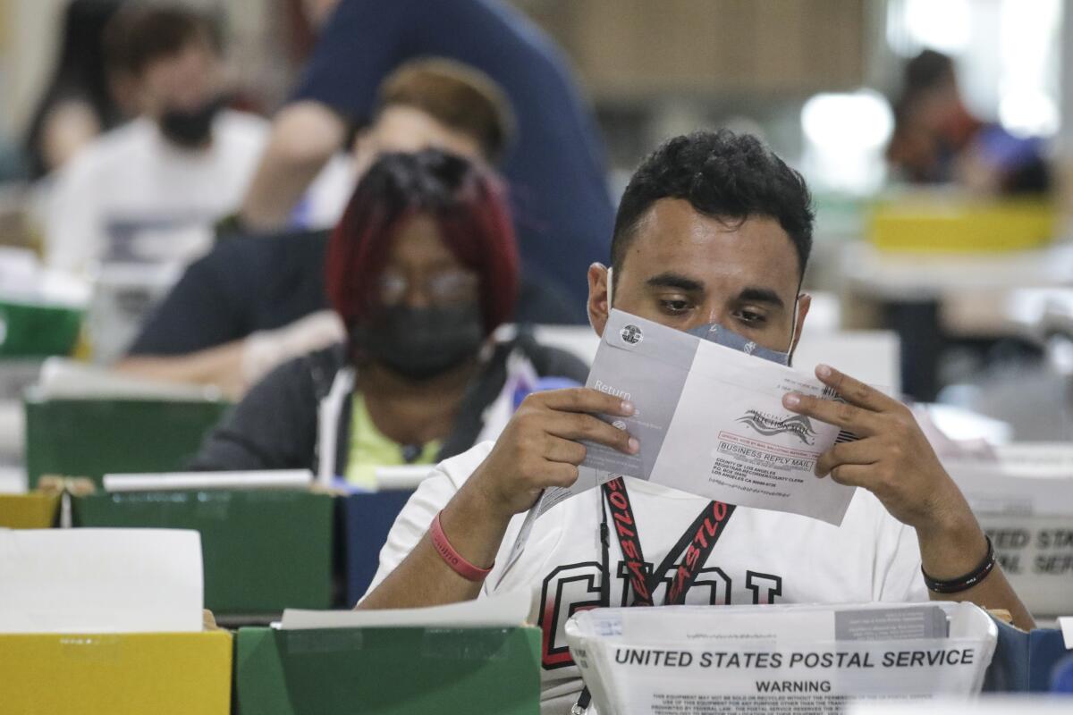 A Los Angeles County election worker inspects a ballot for the recall election in Pomona on Sept. 7. 