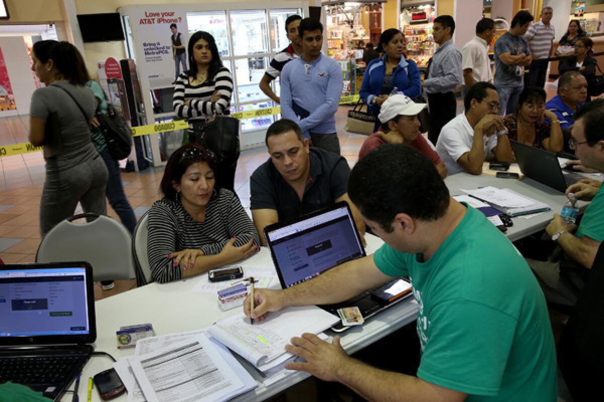 People purchase health insurance under the Affordable Care Act at a kiosk at a mall in Miami earlier this year.