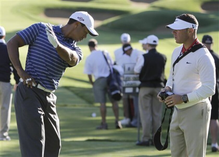 Tiger Woods, left, shows his swing to his swing coach Sean Foley after his tee shot on the fifth hole of a Pro Am round at the 2010 BMW Championship golf tournament in Lemont, Ill., Wednesday, Sept. 8, 2010. (AP Photo/Nam Y. Huh)