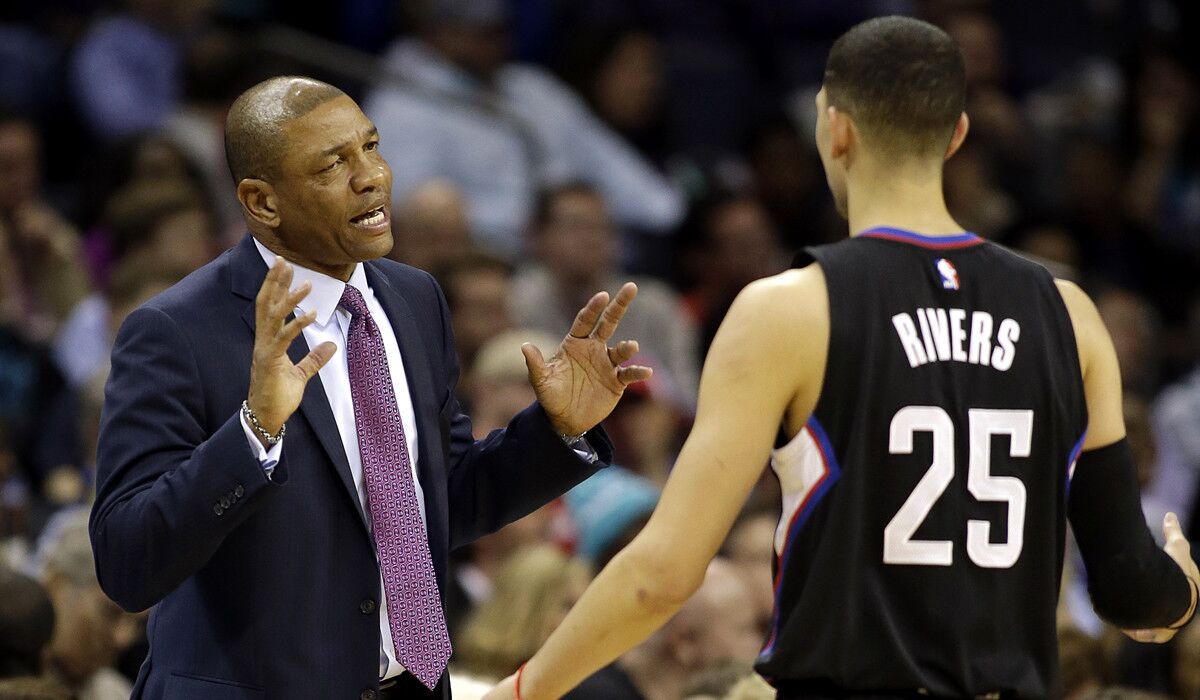 Clippers head coach Doc Rivers, left, makes a point to his son, Austin Rivers, during the first half against the Charlotte Hornets on Wednesday.