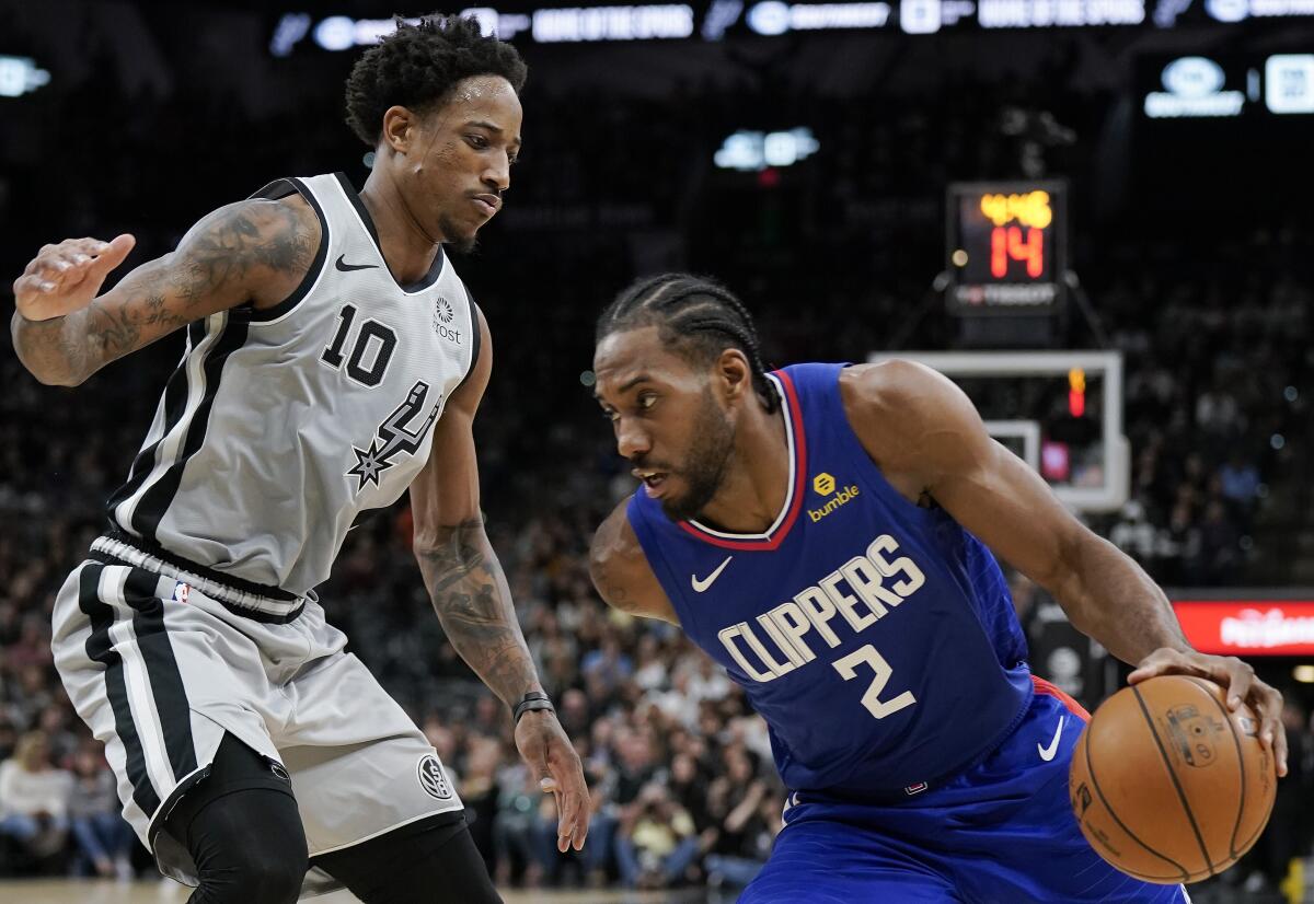Clippers forward Kawhi Leonard tries to drive past Spurs guard DeMar DeRozan during the first half of a game Dec. 21, 2019, in San Antonio.