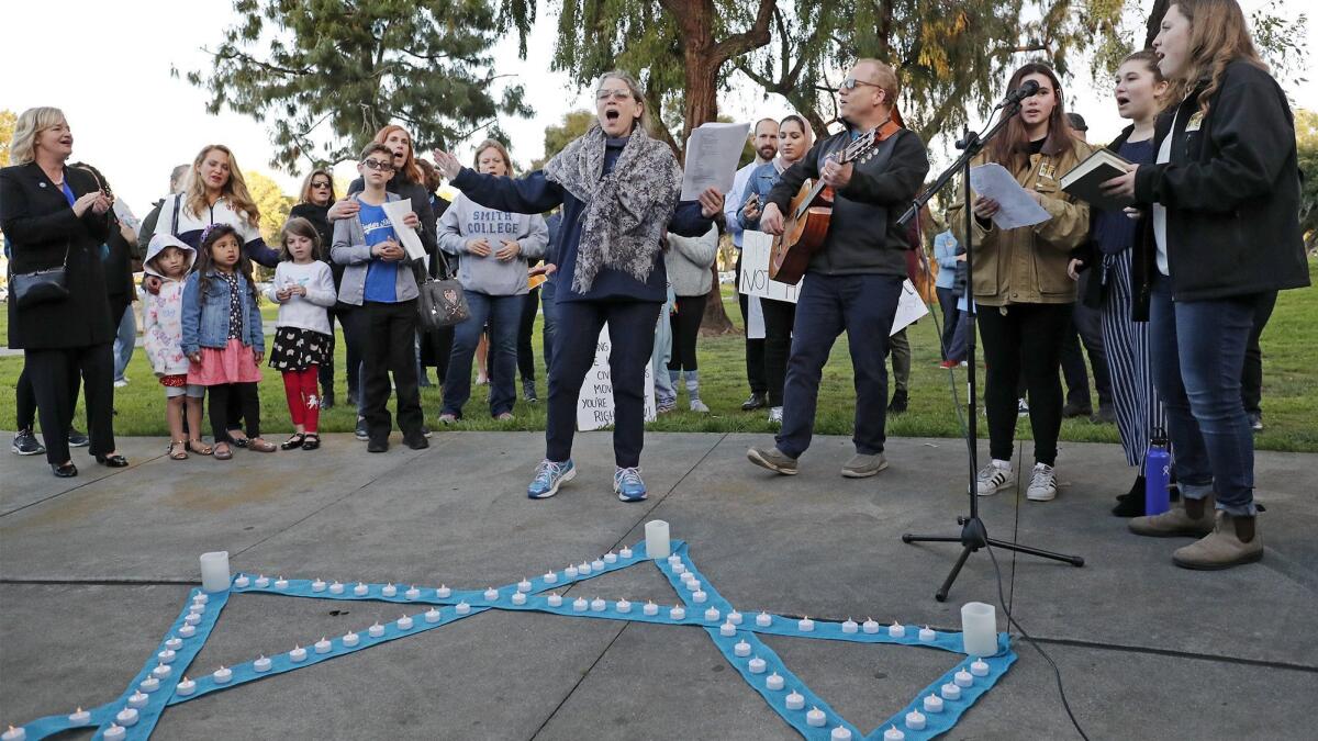 Rabbi Marcia Tilchin, center, Jewish Collaborative of Orange County founder, leads a Shabbat service and vigil at TeWinkle Park in Costa Mesa on March 8. The vigil was held in response to community outrage over photos that featured area high school students giving Nazi salutes.