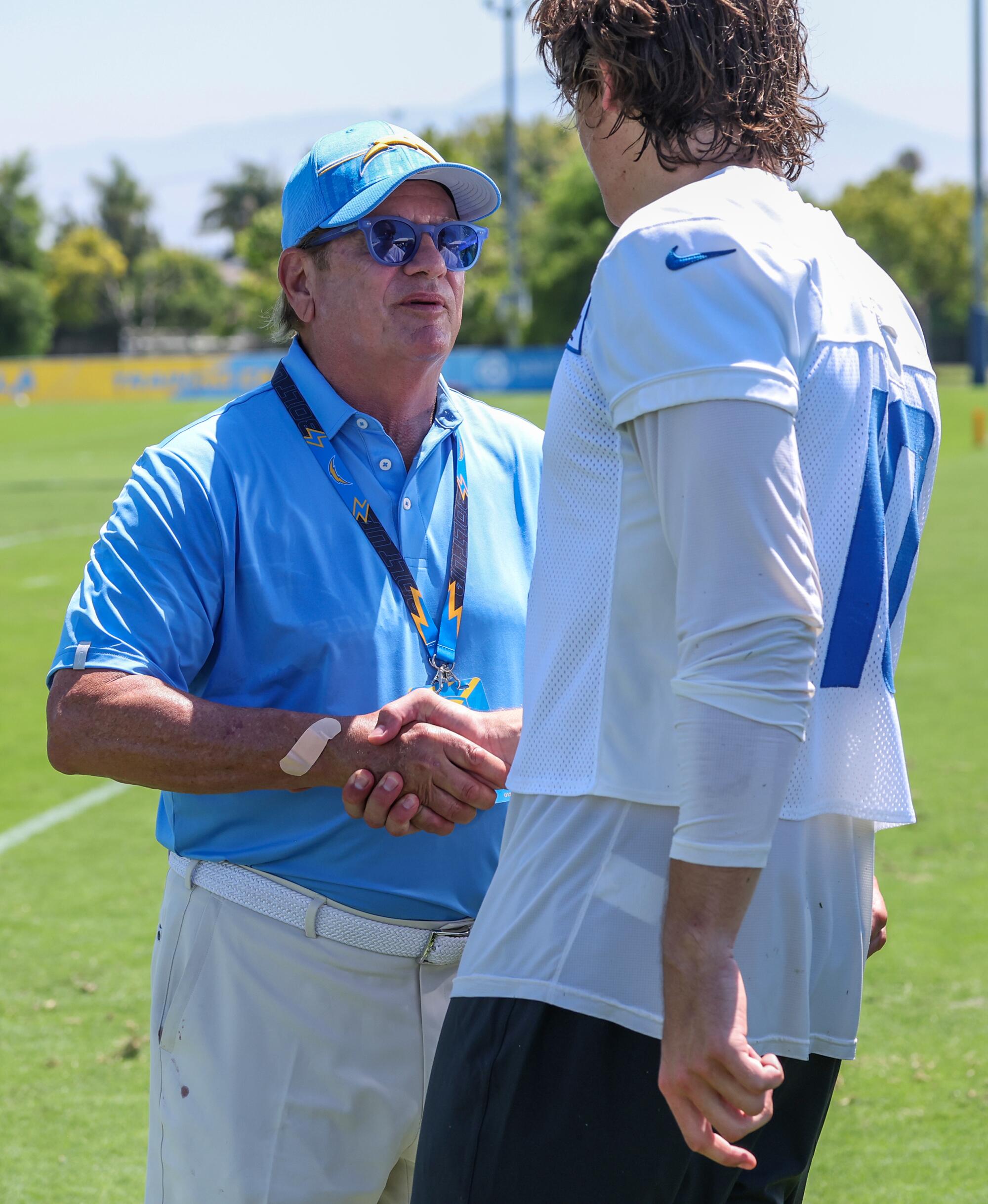 Chargers owner Dean Spanos greets quarterback Justin Herbert during training camp.